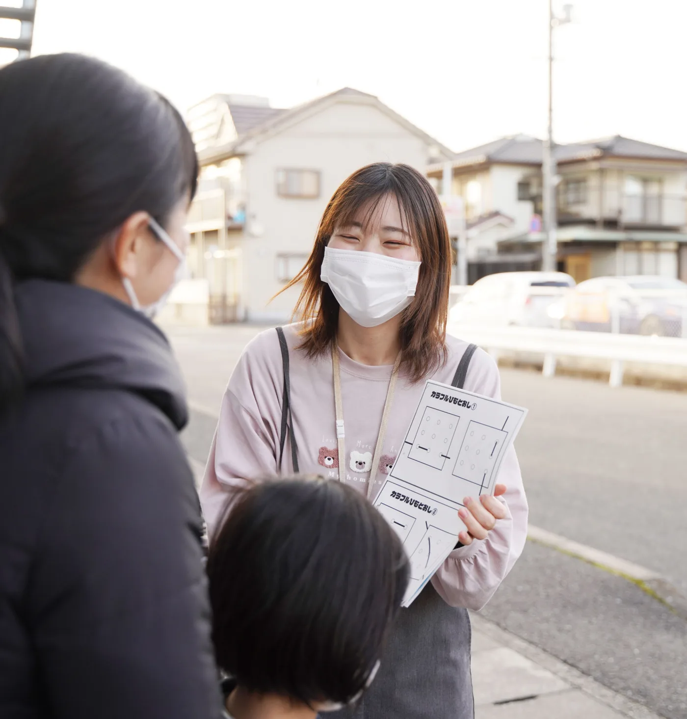 子どもを交えて、笑顔で話す保護者と先生
