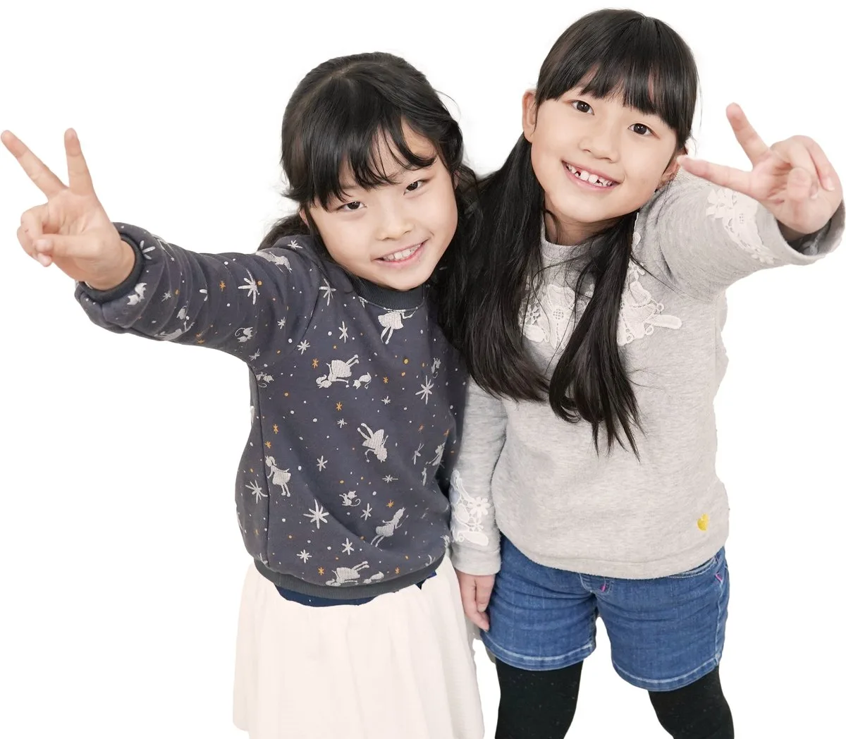 笑顔でピースする小学生の女の子2人